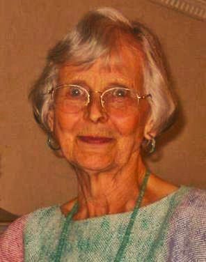 An older woman wearing glasses and a colorful dress.