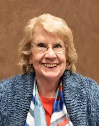 An older woman wearing glasses and a colorful scarf.