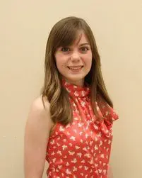 A girl in a red dress posing for a picture.