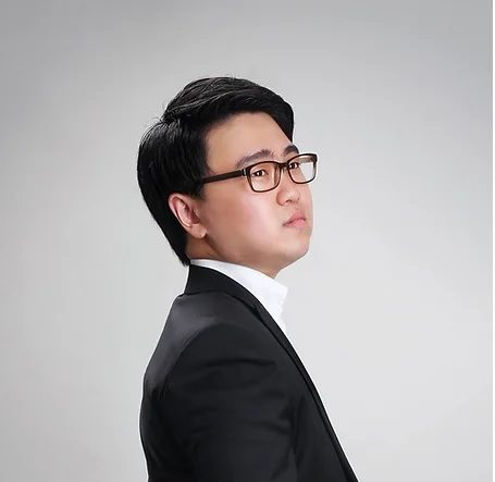 A man in a suit and glasses is posing for a photo.