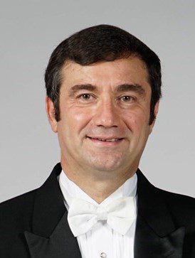 A man in a tuxedo smiling for the camera.