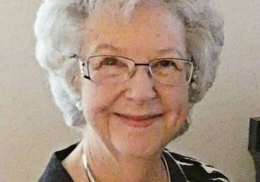 An older woman wearing glasses and a striped top.